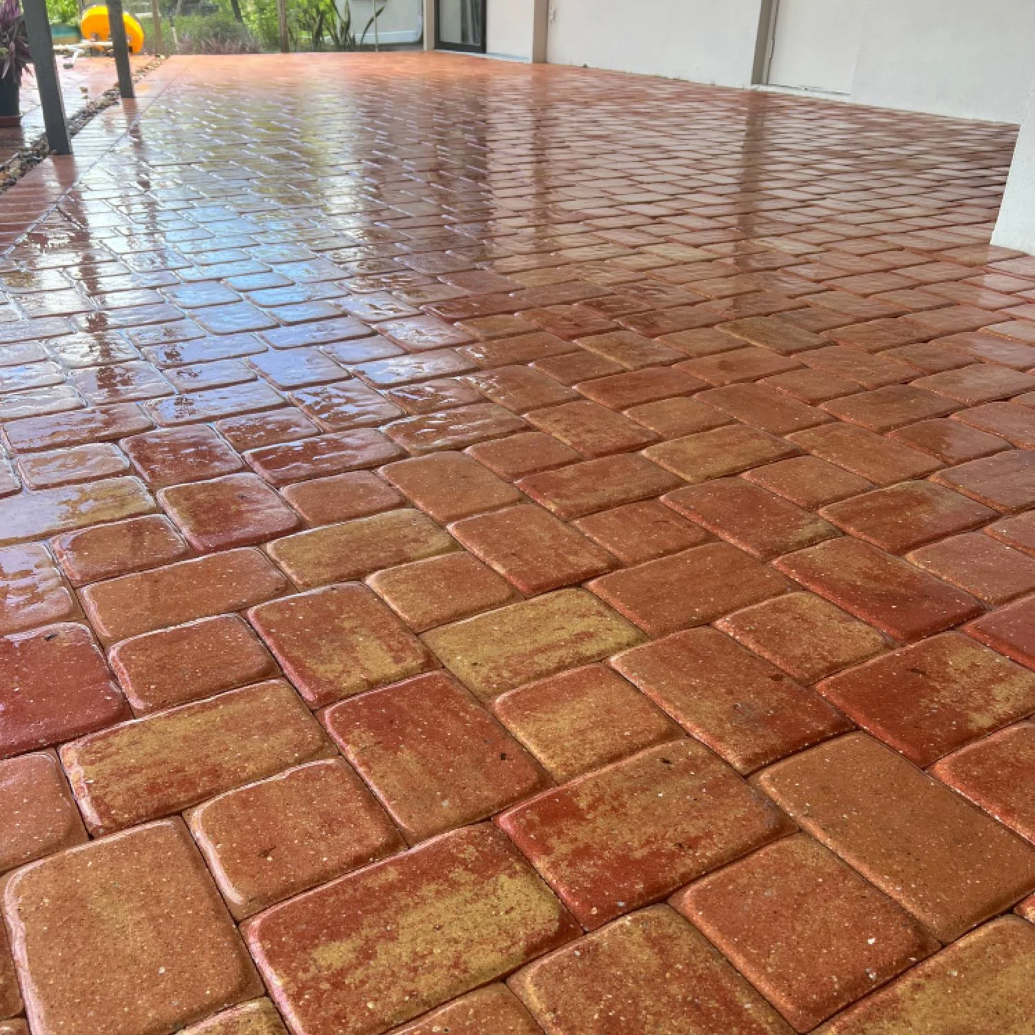 Wet reddish paver patio reflecting light beside a house in Phoenix Arizona