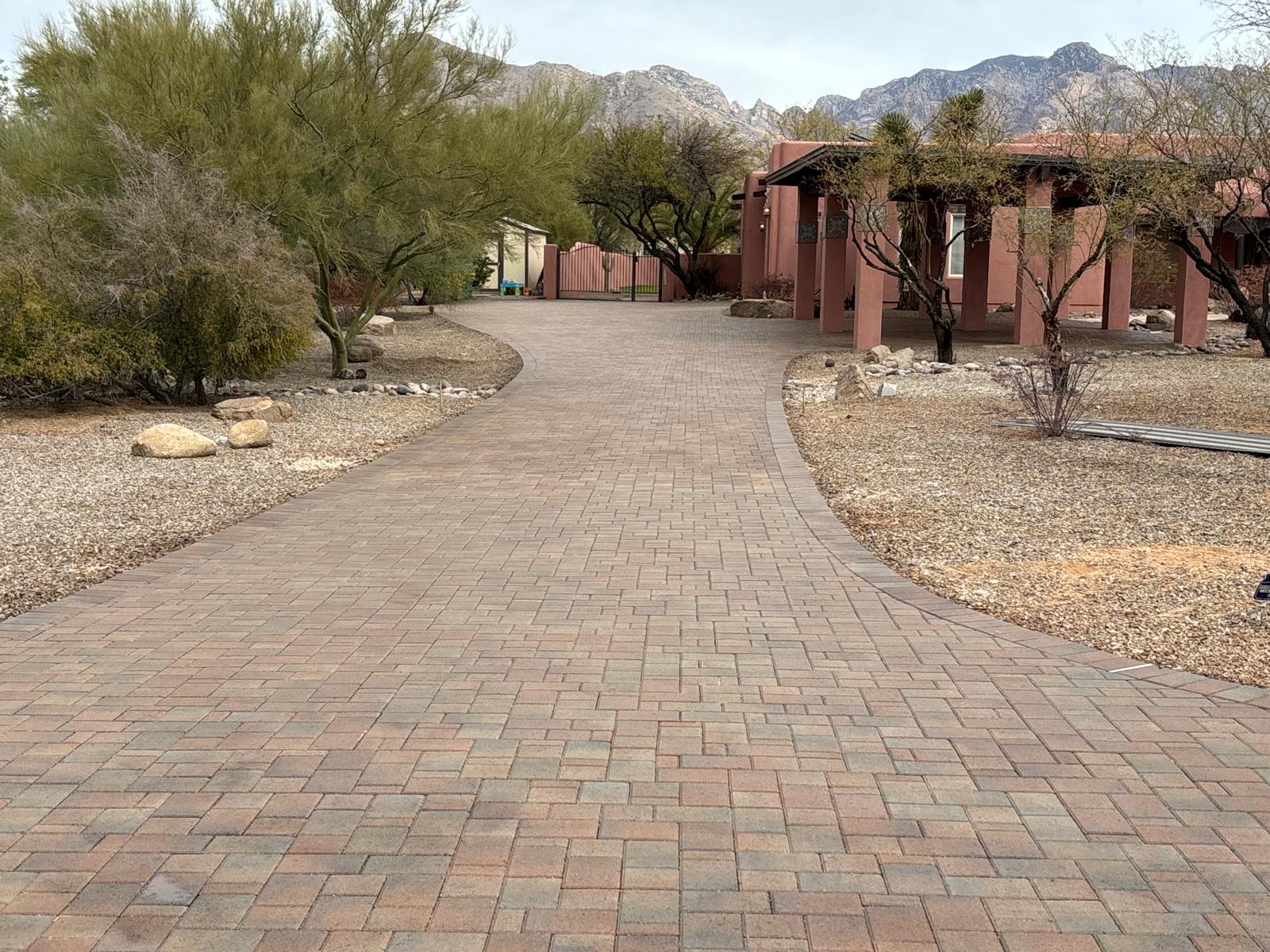 Curved brick paver driveway and walkway through a desert landscape in Arizona