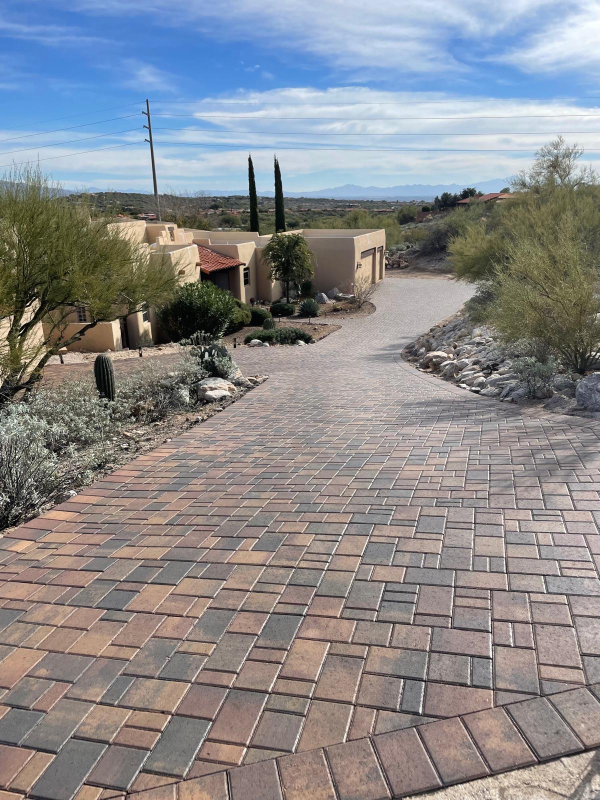 Earth-tone cobble paver driveway winding through a desert home in Arizona