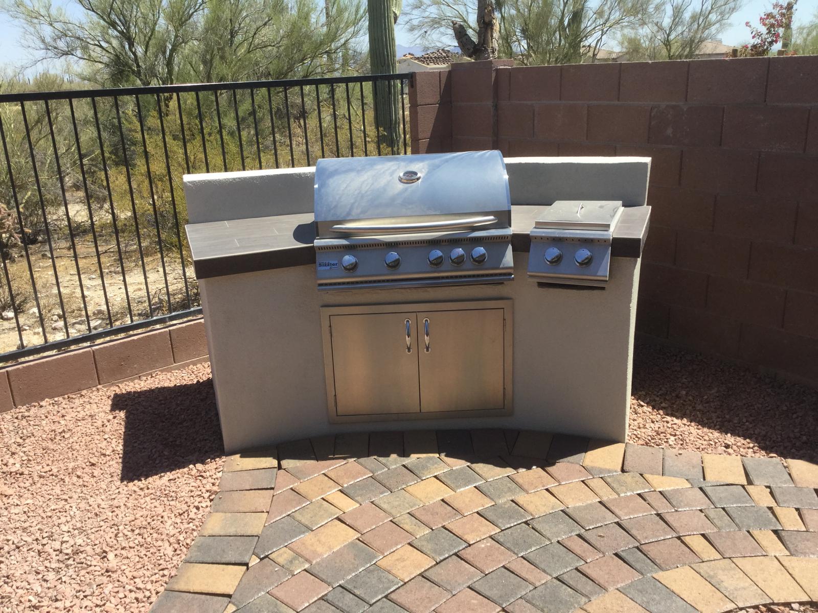 Compact built-in stainless steel barbecue grill and side burner in an Arizona backyard