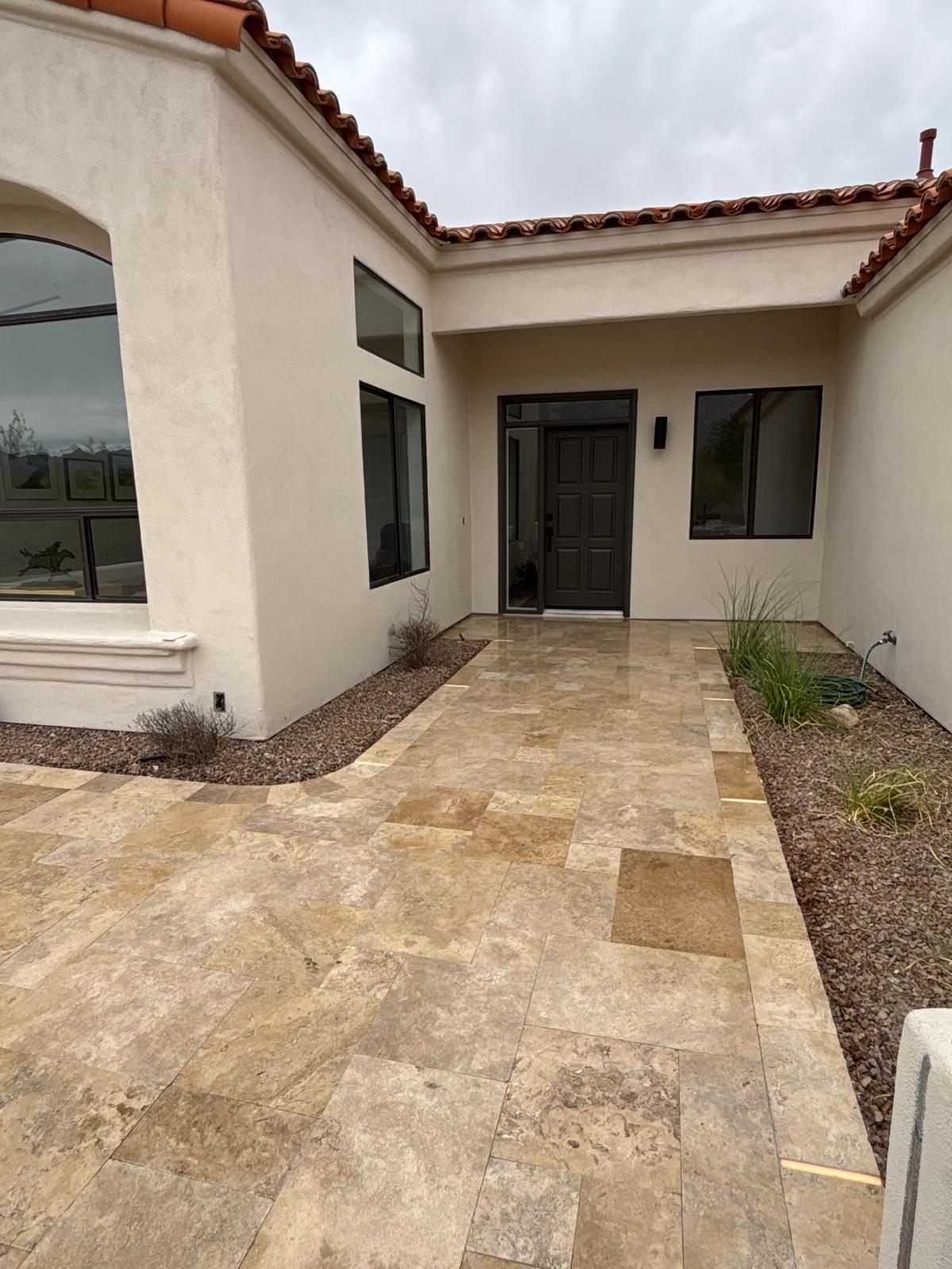 Sealed travertine entry courtyard with tile roof home and desert plants in Arizona