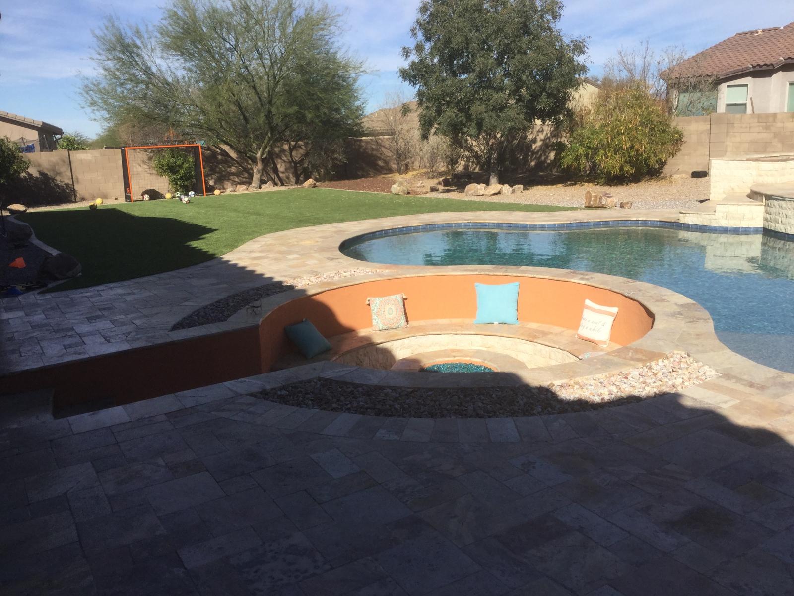 Pool with sunken fire pit lounge, artificial grass and paver deck in Arizona